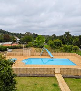a large swimming pool in a landscaped yard at Chácara Segatelli in Cotia