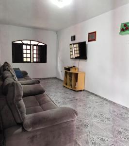 a living room with two couches and a flat screen tv at Chácara Segatelli in Cotia