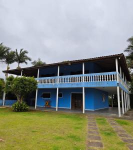 a blue and white building with a yard at Chácara Segatelli in Cotia