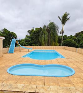 a swimming pool with a slide and a playground at Chácara Segatelli in Cotia +5 photos