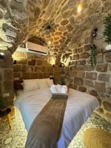 a bedroom with a large bed in a stone wall at Calamari Suite in Acre