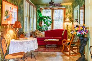 a living room with a red couch and a table at Cliff Cottage Inn, Downtown Bed & Breakfast in Eureka Springs
