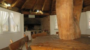 a dining room with a wooden table and a large tree at Cabana Piatra Buru in Buru