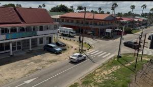 a city street with cars parked in front of buildings at staylikehome guesthouse in Nieuw Nickerie