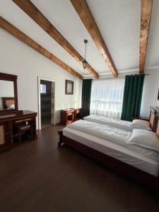 a bedroom with a large bed and a piano at Cabana Piatra Buru in Buru
