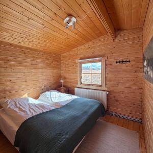 a bedroom with a bed in a wooden cabin at Armuli in Reynistaður