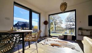a living room with a table and chairs and a large window at Horizont Šumava in Chlum