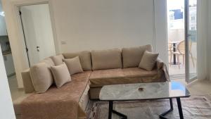 a brown couch in a living room with a table at Golem luxury apartment in Golem +1 photo