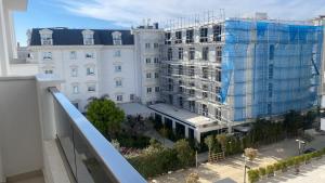a large white building with a reflection of it at Golem luxury apartment in Golem