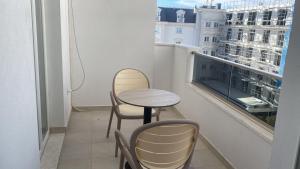 a small table and chairs on a balcony with a window at Golem luxury apartment in Golem