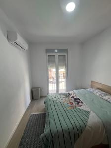 a white bedroom with a bed and a window at Apartamento en el centro vinaros in Vinarós