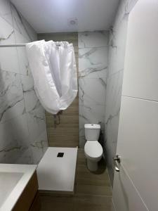 a bathroom with a toilet with a shower curtain at Apartamento en el centro vinaros in Vinarós