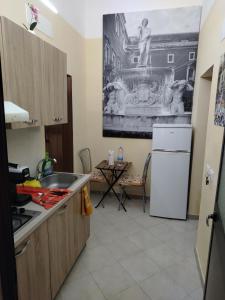a kitchen with a sink and a table with a fountain at Sicilian Room in Catania
