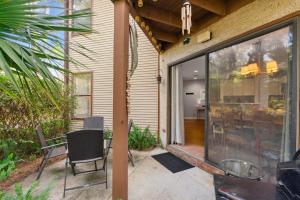 a patio with chairs and a table and a glass door at Harbour Oaks, Unit 419 in Saint Simons Island