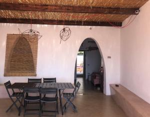 a dining room with a wooden table and chairs at Mare Infinito in Pantelleria