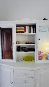a white cabinet with a shelf with books at Mare Infinito in Pantelleria