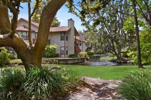 a house with a pond in the yard at Harbour Oaks, Unit 413 in Saint Simons Island