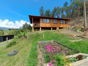 a house on top of a hill with a garden at Cabaña Loto - Paipa in Paipa