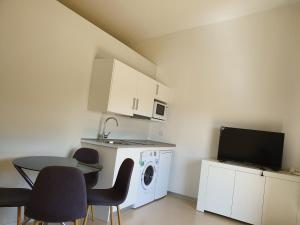 a kitchen with a washing machine and a table with chairs at Camino De Rabe in Rabé de las Calzadas