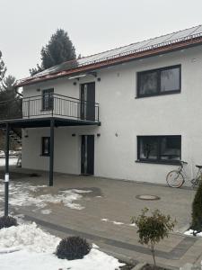 a white house with a balcony and a bike parked outside at Casita 2 in Essenbach