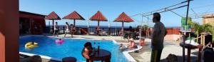 a group of people standing around a swimming pool at Cabañas Ecológicas in Tela in Tela