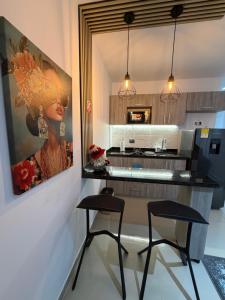 a kitchen with two chairs and a painting on the wall at Luxury Park 35 in Cali +36 photos