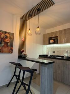 a kitchen with a counter and a bar with a chair at Luxury Park 35 in Cali