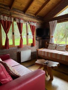a living room with two beds and a tv at Arroyo Escondido in Trevelín +136 photos