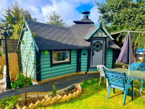 a green play house with a table and chairs at Westcliff Cottage in Southend-on-Sea
