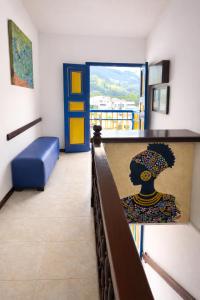 a room with a balcony with a bench and a door at Hospedaje Camino Real in Salento