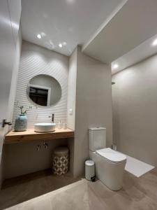a bathroom with a toilet and a sink and a mirror at Jerez Centro Alojamiento Boutique in Jerez de los Caballeros