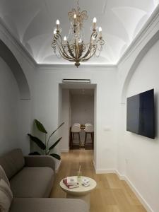 a living room with a couch and a chandelier at Jerez Centro Alojamiento Boutique in Jerez de los Caballeros