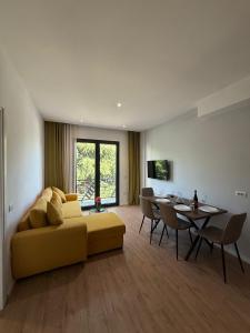 a living room with a yellow couch and a table at Hotel Apart Odeon in Durrës