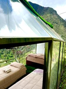 two beds in a tent with a mountain in the background at Hanging Nest Salkantay in Colcapampa
