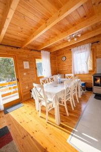 a dining room with a white table and chairs at Guest house Mickovic in Žabljak