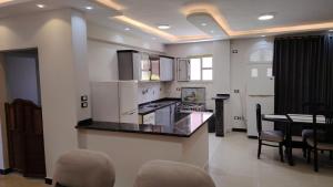 a kitchen with white appliances and a table and chairs at casabianca north coast villa code 112 in Dawwār Muḩammad Abū Shanab