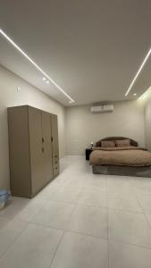 a large bedroom with a bed and a large tiled floor at سويت بغرفتين نوم in Al Majaridah +3 photos