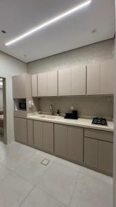 a kitchen with white cabinets and a sink at سويت بغرفتين نوم in Al Majaridah