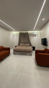 a bedroom with a bed and two couches at سويت بغرفتين نوم in Al Majaridah