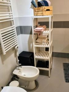 a bathroom with a toilet and a shelf with towels at Resta Con Me in Genoa