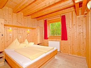 シュトゥンムにあるChalet mit Sauna und Kamin A 257.001の木製の部屋にベッド1台が備わるベッドルーム1室があります。