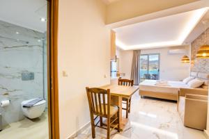 a room with a dining table and a bedroom at Dolphin Hotel Apartments in Karpathos +148 photos