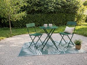 a table and two chairs sitting next to a patio at Le Petit Rocher in Pierrelatte +5 photos