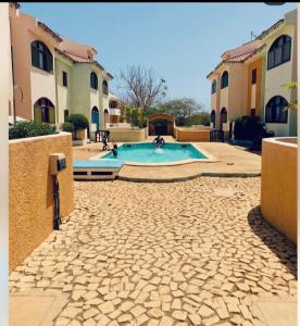 a swimming pool in a courtyard with two buildings at Carla Tryana Fernandes Castro in Vila do Porto