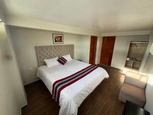 a bedroom with a large white bed and a chair at Hotel Inka House Chinchero in Chincheros +22 photos