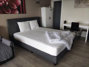 a bed with white sheets in a room at Studio met zeezicht in Blankenberge