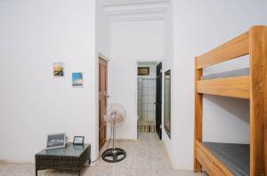 a room with a bunk bed and a desk and a fan at Avellanas Surf Hostel in Playa Avellana
