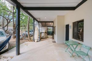 a garage with a table and a house at Avellanas Surf Hostel in Playa Avellana +2 photos