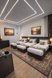 a living room with four beds and a television at El Mohandseen Cairo Hotel in Cairo