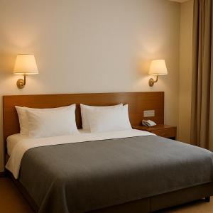 a bed in a hotel room with two lamps at El Mohandseen Cairo Hotel in Cairo